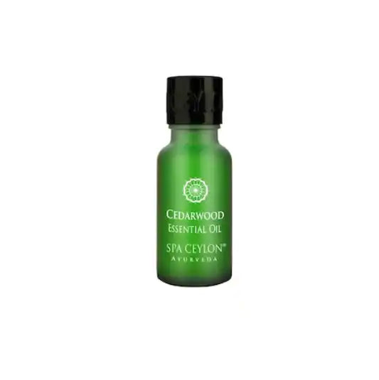 Green bottle of cedarwood essential oil for aromatherapy and wellness on white background