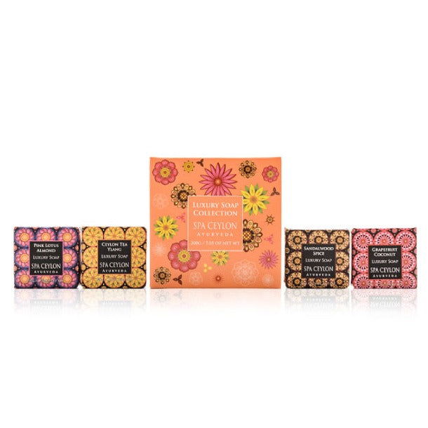 Assorted luxury soap bars with colorful, floral packaging arranged in a row on a white background.