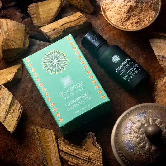 Cedarwood essential oil bottle and box with wood pieces and bowl of powder on a rustic surface