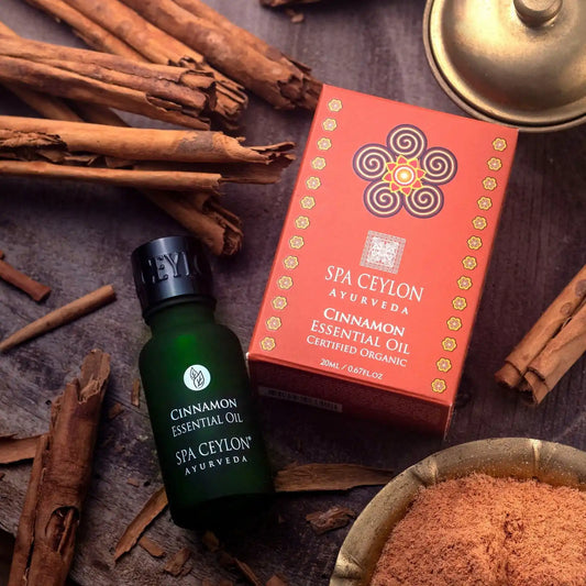 Cinnamon essential oil bottle and box with cinnamon sticks and powder on wooden surface