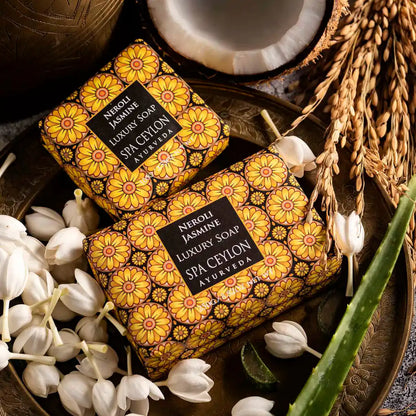 Neroli Jasmine luxury soap bars with floral packaging, surrounded by jasmine flowers, coconut, grains, and aloe vera.